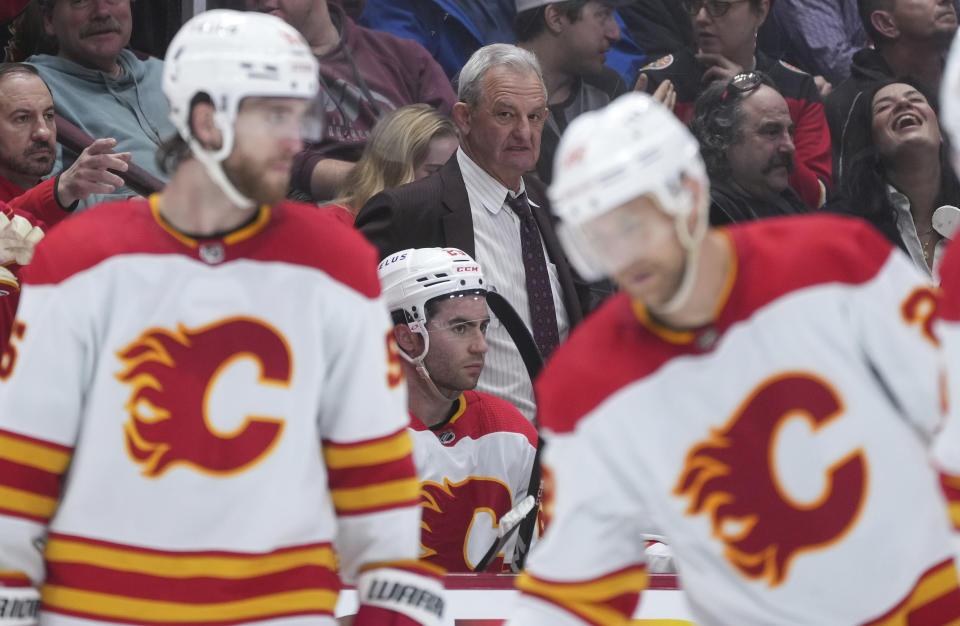 Calgary Flames coach Darryl Sutter stands behind the bench during the third period of the team's NHL hockey game against the Vancouver Canucks on Friday, March 31, 2023, in Vancouver, British Columbia. (Darryl Dyck/The Canadian Press via AP)