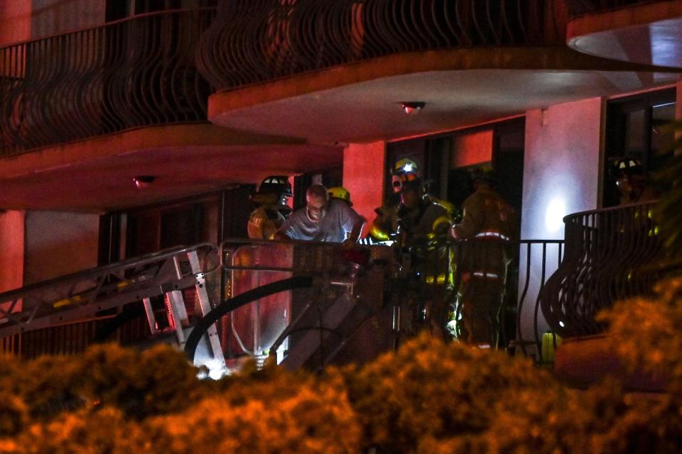 Fire Rescue workers rescue a resident at the partially collapsed condominium in Surfside.