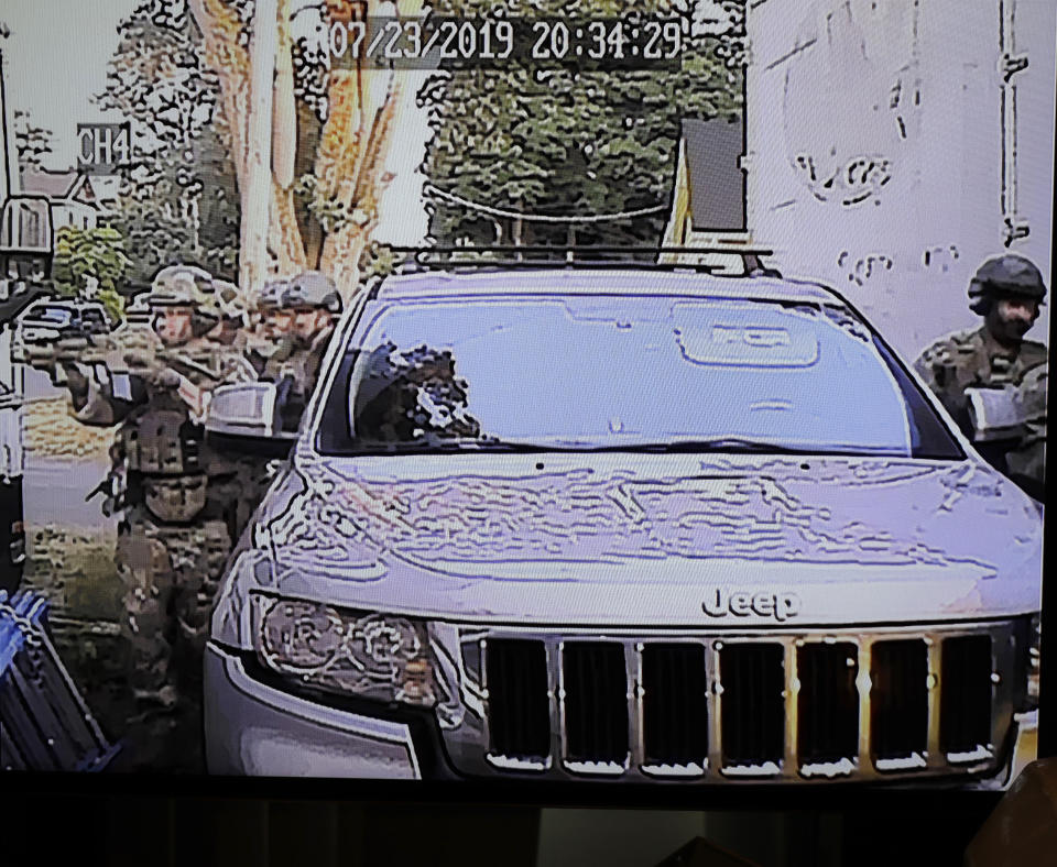 In this image made from a Monday, July 29, 2019, security camera video provided by a neighbor who has requested not to be identified, federal agents conduct a raid on the home of Paige A. Thompson in Seattle. Thompson is accused of accessing the personal information of millions of Capital One credit card holders or credit card applicants in the U.S. and Canada. The time and date stamp on the image is inaccurate, as the raid took place on Monday, July 29, 2019. (Courtesy Photo via AP)