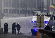 Police set off a water cannon against protestors during a demonstration against COVID-19 measures in Brussels, Sunday, Jan. 23, 2022. Demonstrators gathered in the Belgian capital to protest what they regard as overly extreme measures by the government to fight the COVID-19 pandemic, including a vaccine pass regulating access to certain places and activities and possible compulsory vaccines. (AP Photo/Geert Vanden Wijngaert)