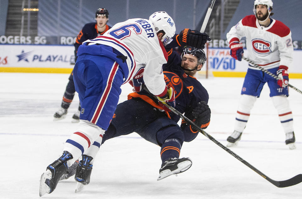 Edmonton Oilers' Leon Draisaitl (29) is checked by Montreal Canadiens' Shea Weber (6) during the second period of an NHL hockey game, Wednesday, April 21, 2021 in Edmonton, Alberta. (Jason Franson/The Canadian Press via AP)