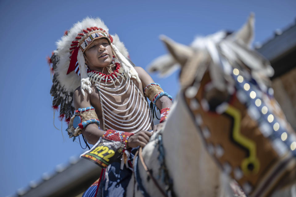 Fourteen year-old Mylan Archuleta of Ohkay Owingeh village in northern New Mexico prepares to ride his horse in the horse parade at the 40th anniversary of the Gathering of Nations Pow Wow in Albuquerque, N.M., Friday, April 28, 2023. Tens of thousands of people gathered in New Mexico on Friday for what organizers bill as the largest powwow in North America. (AP Photo/Roberto E. Rosales)