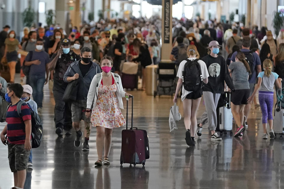 FILE - In this July 1, 2021, file photo, people walk through Salt Lake City International Airport in Salt Lake City. Americans enjoying newfound liberty are expected to travel and gather for cookouts, fireworks and family reunions over the Fourth of July weekend in numbers not seen since pre-pandemic days. (AP Photo/Rick Bowmer, File)