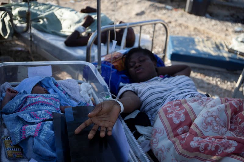 A woman on a stretcher is pictured with a baby after a 7.2 magnitude earthquake in Les Cayes