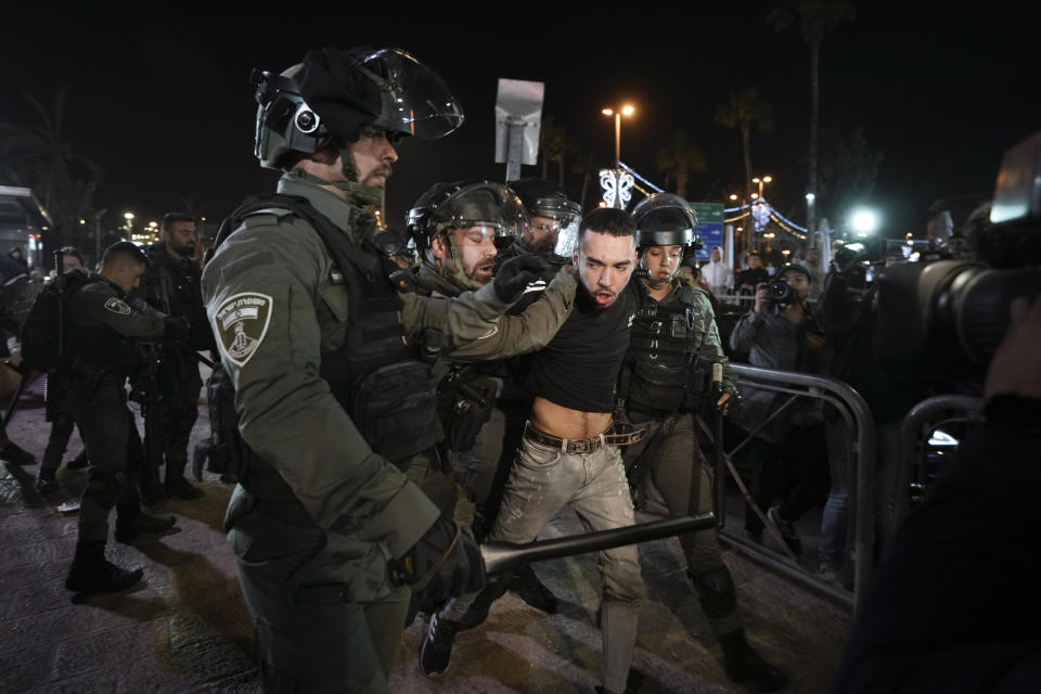 FILE - Israeli border police officers detain a protester during clashes between Israeli security forces and Palestinians next to Damascus Gate, outside the Old City of Jerusalem, during the Muslim holy month of Ramadan, April 4, 2022. Days of violence in Jerusalem and an exchange of fire in Gaza overnight have raised the possibility that Israel and Gaza's Hamas rulers will once again go to war, as they did less than a year ago under similar circumstances. This time around, both Israel and Hamas have powerful incentives to preserve calm — but do not want to be seen as retreating from a Jerusalem holy site at the heart of the century-old Mideast conflict. (AP Photo/Mahmoud Illean, File)