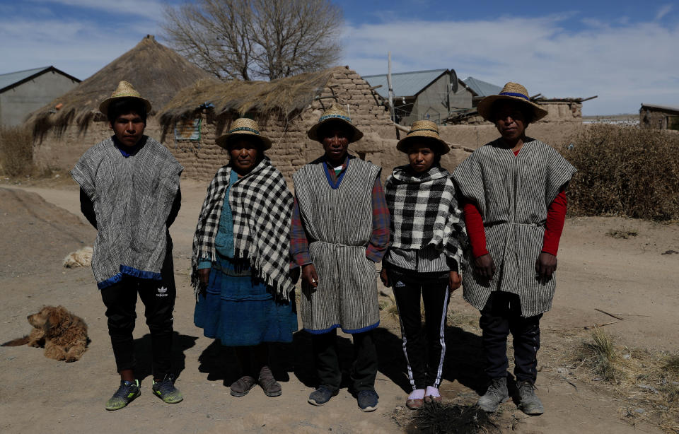 Members of the Choque family, from left, Jose, Evarista Flores, Rufino, Abelina and Abdon, pose for a photo in the Urus del Lago Poopo indigenous community, in Punaca, Bolivia, Sunday, May 23, 2021. With no land for farming, the young men hire themselves out as laborers, herders or miners in nearby towns or more distant cities. “They see the money and they don't return,” said Abdon. (AP Photo/Juan Karita)