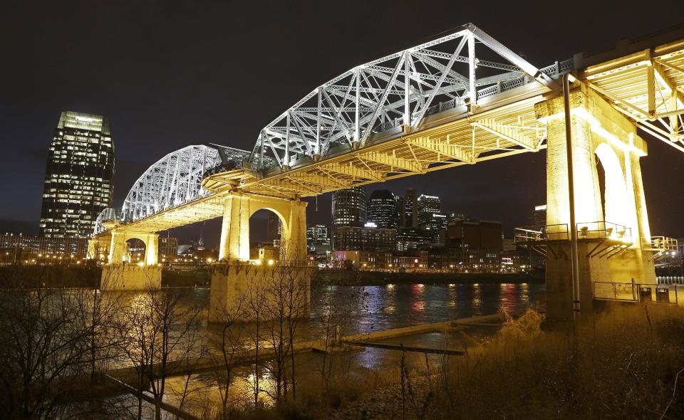 This Jan. 15, 2014 photo shows the Shelby Street pedestrian bridge spanning the Cumberland River in Nashville, Tenn. The banks of the Cumberland River in downtown Nashville are more than a place to watch barges pass. The bridge is one of the best viewpoints for the Nashville skyline that inspired Bob Dylan to write a country album. (AP Photo/Mark Humphrey)