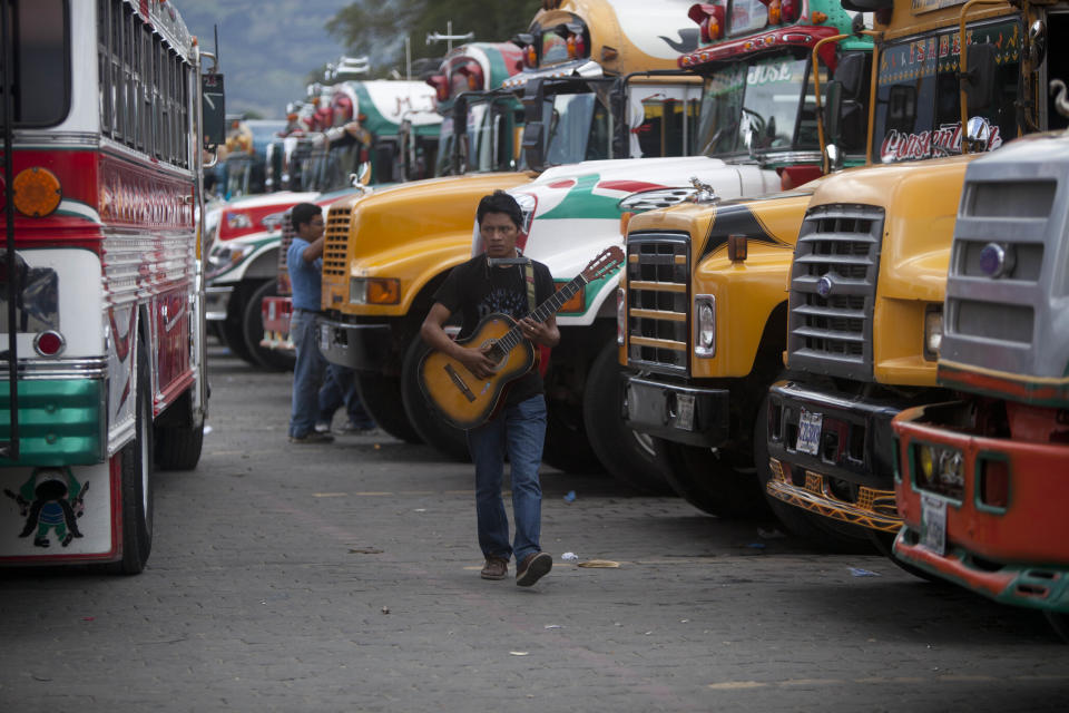 In this Nov. 14, 2013 photo, musican Gabino Calmo Geronimo, 24 years-old, walks with his guitar on the bus terminal in Antigua, Guatemala. In recent months, however, this UNESCO World Heritage Site has seen the troubles of the outside world threaten the town’s backpacker charm. Vehicle and home burglaries are up, and once-reliable public services such as water and trash collection have been left unattended across whole blocks.(AP Photo/Luis Soto)