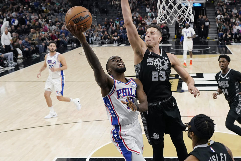 Philadelphia 76ers guard Shake Milton (18) drives to the basket against San Antonio Spurs forward Zach Collins (23) during the first half of an NBA basketball game in San Antonio, Friday, Feb. 3, 2023. (AP Photo/Eric Gay)
