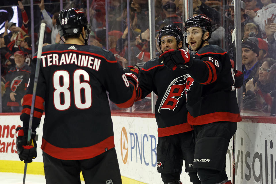 Carolina Hurricanes' Michael Bunting (58) celebrates after his goal with teammates Teuvo Teravainen (86) and Seth Jarvis, center, during the second period of an NHL hockey game against the Colorado Avalanche in Raleigh, N.C., Thursday, Feb. 8, 2024. (AP Photo/Karl B DeBlaker)