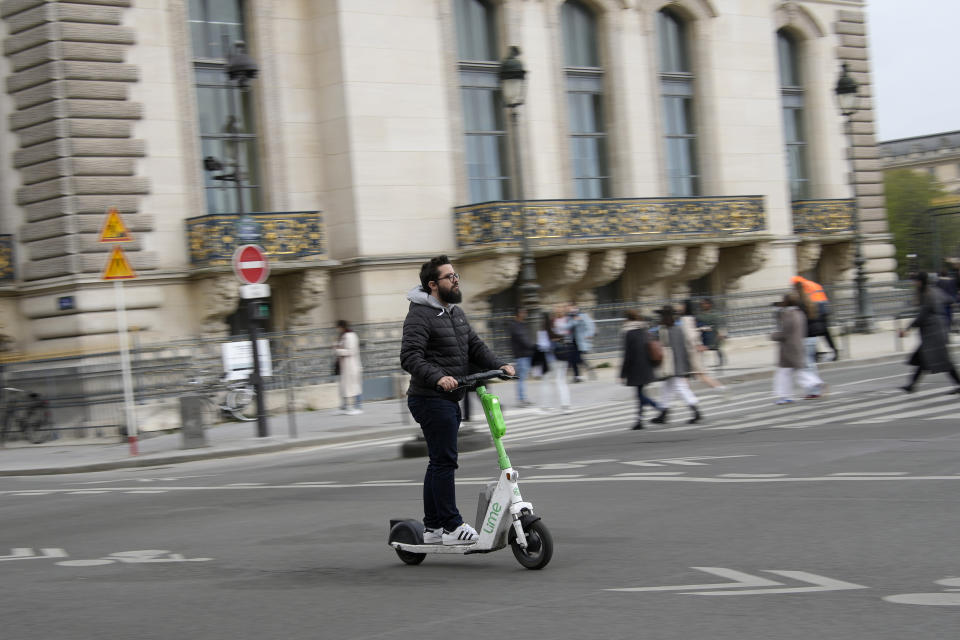 A man rides a scooter in Paris, Friday, march 31, 2023. Romantically zipping two-to-a-scooter, wind in the hair, past the Eiffel Tower and other iconic sights could soon become a thing of the past if Parisians vote Sunday to do away with the 15,000 opinion-dividing micro-machines. (AP Photo/Christophe Ena)