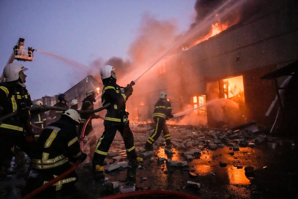 Firefighters extinguish a blaze at a warehouse after a bombing in Kyiv on Thursday (AP)