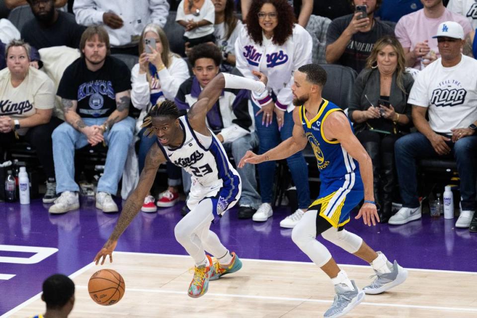 Sacramento Kings guard Keon Ellis (23) drives to the basket against Golden State Warriors guard Stephen Curry (30) on Tuesday.