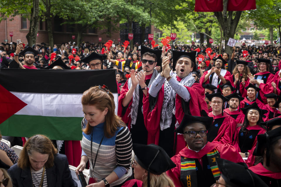 Students applaud next to a Palestinian flag, as the 13 students who have been barred from graduating due to protest activities are recognized by a student address speaker, during commencement in Harvard Yard, at Harvard University, in Cambridge, Mass., Thursday, May 23, 2024. (AP Photo/Ben Curtis)