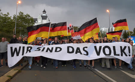 FILE PHOTO: People attend a far-right "Pro Chemnitz" group demonstration in Chemnitz, Germany, September 7, 2018. The banner reads: "We are the people". REUTERS/Matthias Rietschel/File Photo