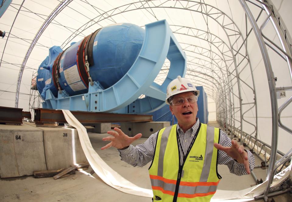 FILE - Buzz Miller, executive vice president of nuclear development at Southern Co., stands in front of the high-pressure vessel used in one of the two new nuclear reactor at Plant Vogtle on June 13, 2014, in Waynesboro, Ga. The nuclear industry promised a new generation of plants would be built using giant Lego-like modules, leading to faster, cheaper, higher-quality construction. Instead, the Louisiana factory building the modules failed to meet quality standards, schedules or approved designs, leading to delays and cost overruns. (AP Photo/John Bazemore, File)