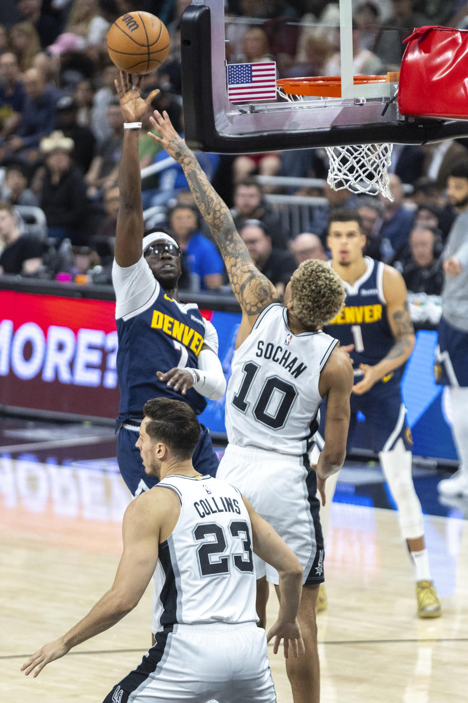 Denver Nuggets guard Reggie Jackson (7) looks to score over San Antonio Spurs forward Jeremy Sochan (10) and forward Zach Collins (23) during the first half of an NBA basketball game, Friday, March 15, 2024, in Austin, Texas. (AP Photo/Stephen Spillman)