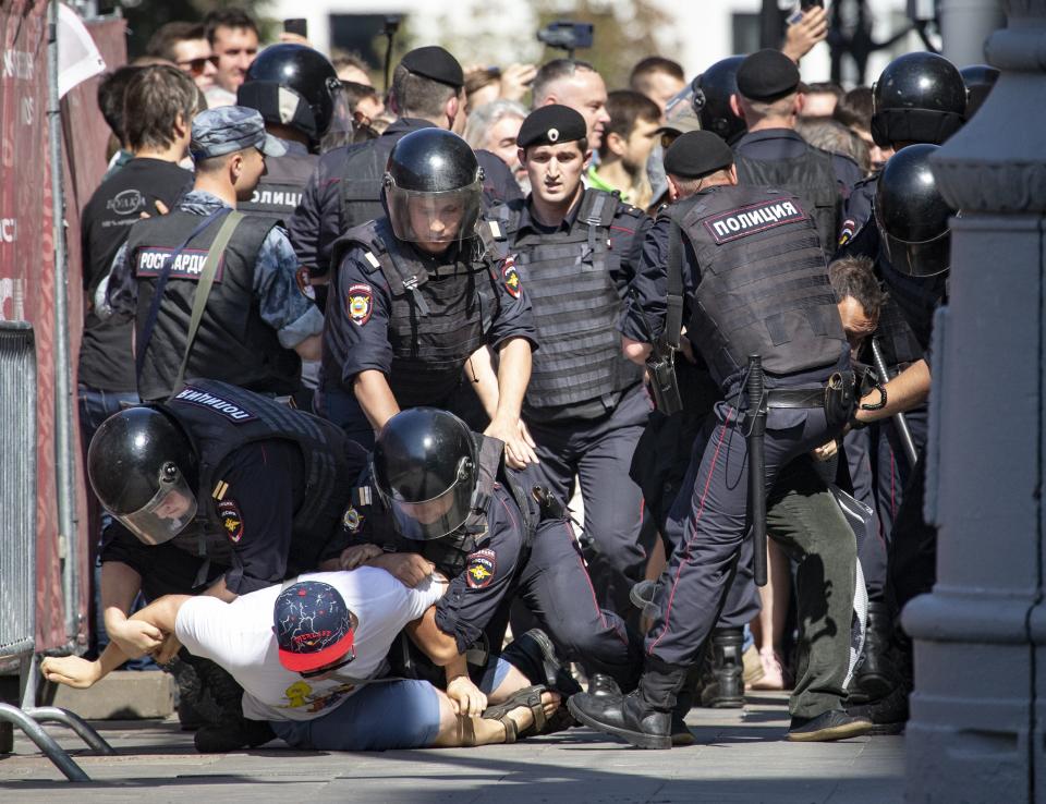 Police officers detain protesters during an unsanctioned rally in the center of Moscow, Russia, Saturday, July 27, 2019. Russian police cracked down fiercely Saturday on demonstrators in central Moscow, beating some people and arresting more than 1,000 who were protesting the exclusion of opposition candidates from the ballot for Moscow city council. Police also stormed into a TV station broadcasting the protest. (AP Photo/Alexander Zemlianichenko)