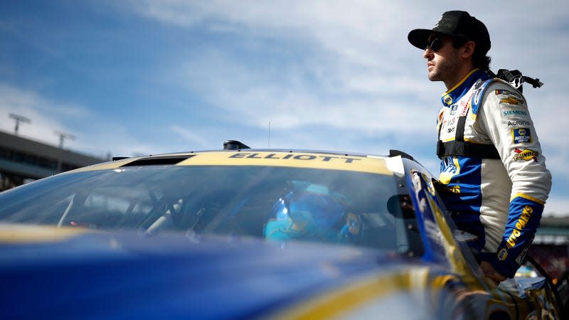 A photo of Nascar driver Chase Elliott sitting on the window of his car. 