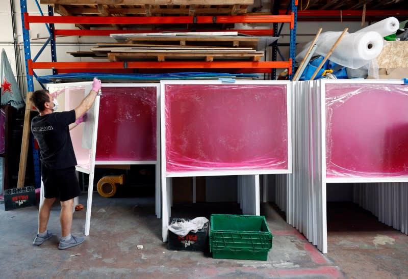 A worker paints the structure of a plexiglass screen at Social Windows company in Nivelles