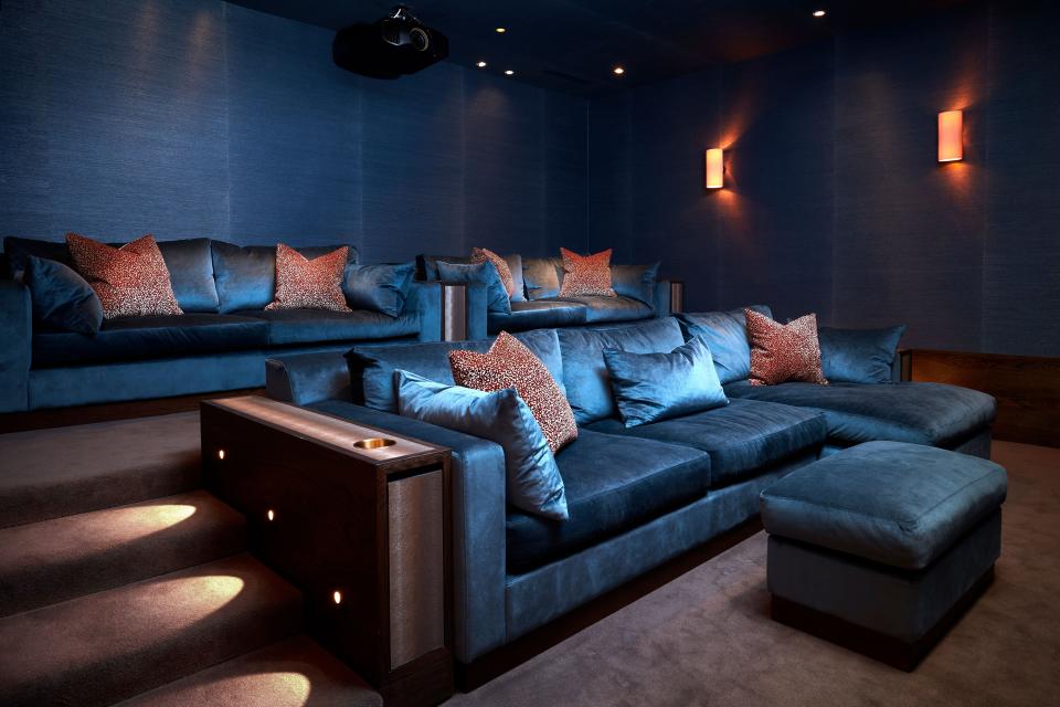 Lined in midnight blue–dyed hemp by Phillip Jeffries, the home cinema features sofas made by Orior using Elitis fabric. The wall lights are from Jim Lawrence while all the joinery is by Abington Design House.