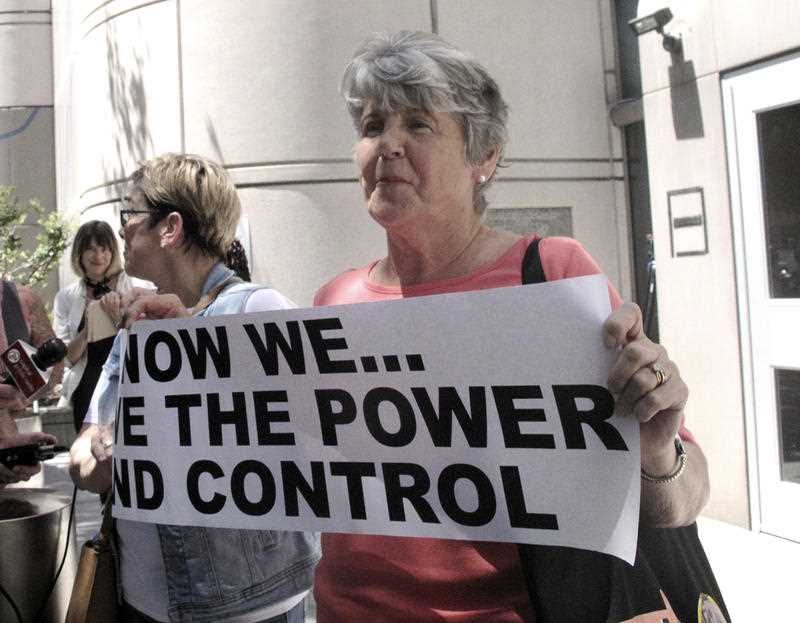 Jane Carson-Sandler, of South Carolina, who was raped by the so-called Golden State Killer in 1976, holds a sign with a message to her attacker in Sacramento.