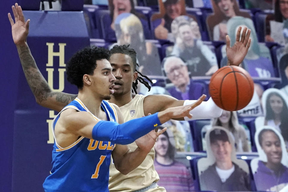 UCLA guard Jules Bernard (1) passes as Washington forward Hameir Wright defends during the first half of an NCAA college basketball game Saturday, Feb. 13, 2021, in Seattle. (AP Photo/Ted S. Warren)