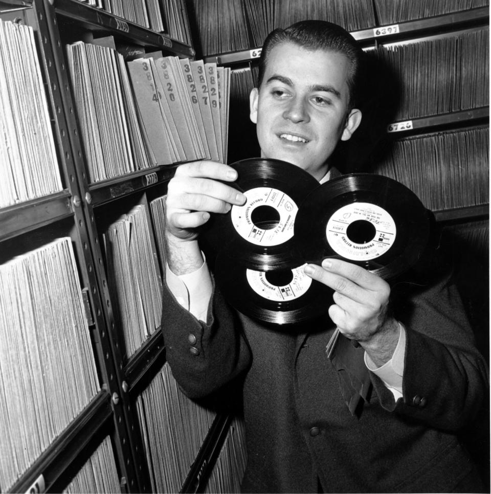 FILE - In this Feb. 3, 1959 file photo, Dick Clark selects a record in his station library in Philadelphia. Clark, the television host who helped bring rock `n' roll into the mainstream on "American Bandstand," died Wednesday, April 18, 2012 of a heart attack. He was 82. (AP Photo/File)