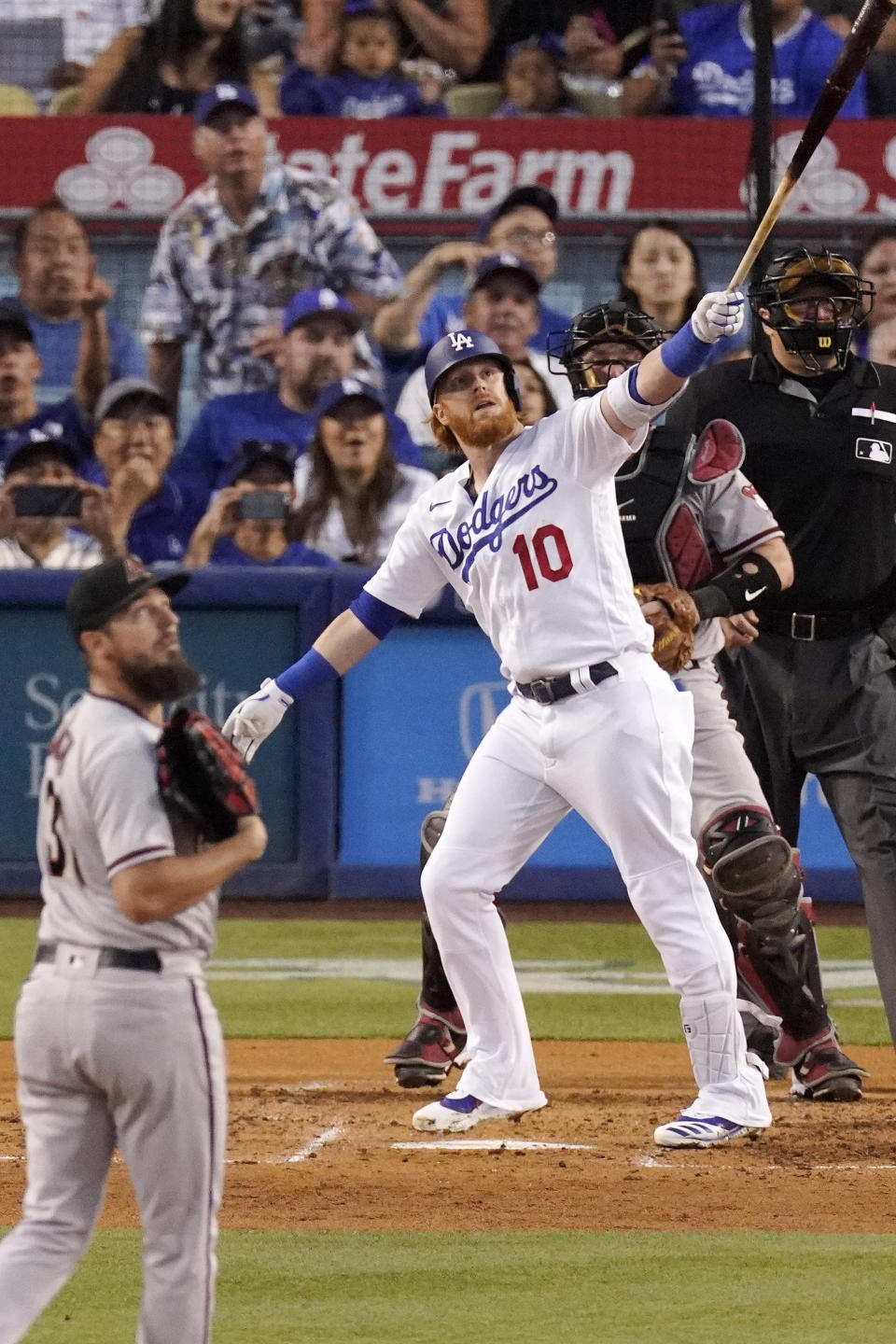 Los Angeles Dodgers' Justin Turner, second from left, hits a grand slam as Arizona Diamondbacks starting pitcher Caleb Smith, left, and catcher Bryan Holaday, second from right, watch along with home plate umpire Tony Randazzo during the second inning of a baseball game Saturday, July 10, 2021, in Los Angeles. (AP Photo/Mark J. Terrill)