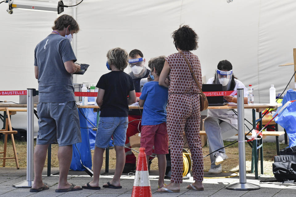 Travelers arrive at a test station to make a COVID-19 test at the airport in Cologne, Germany, Tuesday, July 28, 2020. New test centers for coronavirus are established at German airports due to the pandemic and free corona tests are given for returnees from countries designated as risk areas. (AP Photo/Martin Meissner)