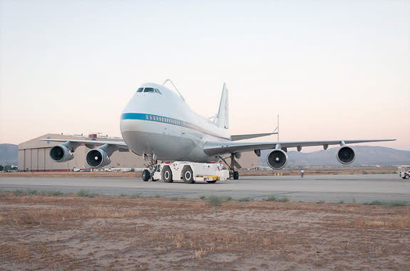 NASA 911, one of two retired Shuttle Carrier Aircraft that ferried NASA's space shuttles across the country for three decades, is towed from NASA Armstrong Flight Research Center's Building 703 on its final journey to the City of Palmdale's nea