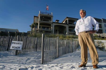 Coastal engineer Terry Anderson stands near the dunes that he created behind former Arkansas Governor Mike Huckabee's house (top C) on the Gulf Coast in Santa Rosa Beach, Florida, June 29, 2014. Picture taken June 29, 2014. REUTERS/Phil Sears