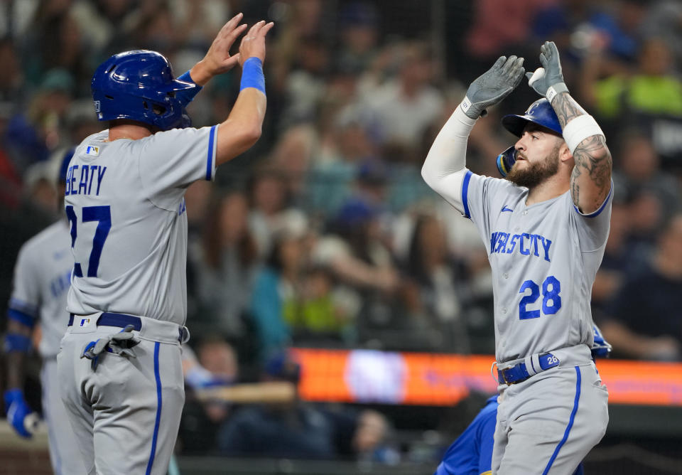 Kansas City Royals' Matt Beaty (27) greets Kyle Isbel (28) after scoring in Isbel's two-run home run against the Seattle Mariners during the seventh inning of a baseball game Friday, Aug. 25, 2023, in Seattle. (AP Photo/Lindsey Wasson)