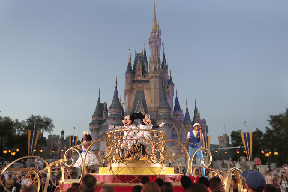 FILE - Mickey and Minnie Mouse perform during a parade as they pass by the Cinderella Castle at the Magic Kingdom theme park at Walt Disney World in Lake Buena Vista, Fla., on Jan. 15, 2020. After appointees of Florida Gov. Ron DeSantis took over Walt Disney World’s governing district in 2023, its firefighters were among the few employees who publicly welcomed them with open arms. But that warm relationship is in jeopardy now as a new administrator has reopened negotiations on a new contract that promised pay raises and more manpower for the more than 200 unionized firefighters and other first-responders. (AP Photo/John Raoux, File)