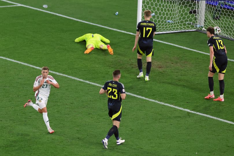 Scotland stand dejected as Kevin Csoboth of Hungary celebrates scoring.