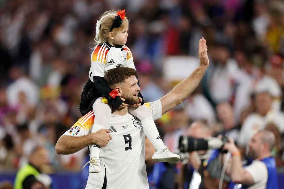 MUNICH, GERMANY - JUNE 14: Niclas Fuellkrug of Germany celebrates with his daughter at full-time following the team's victory in the UEFA EURO 2024 group stage match between Germany and Scotland at Munich Football Arena on June 14, 2024 in Munich, Germany. (Photo by Lars Baron/Getty Images)