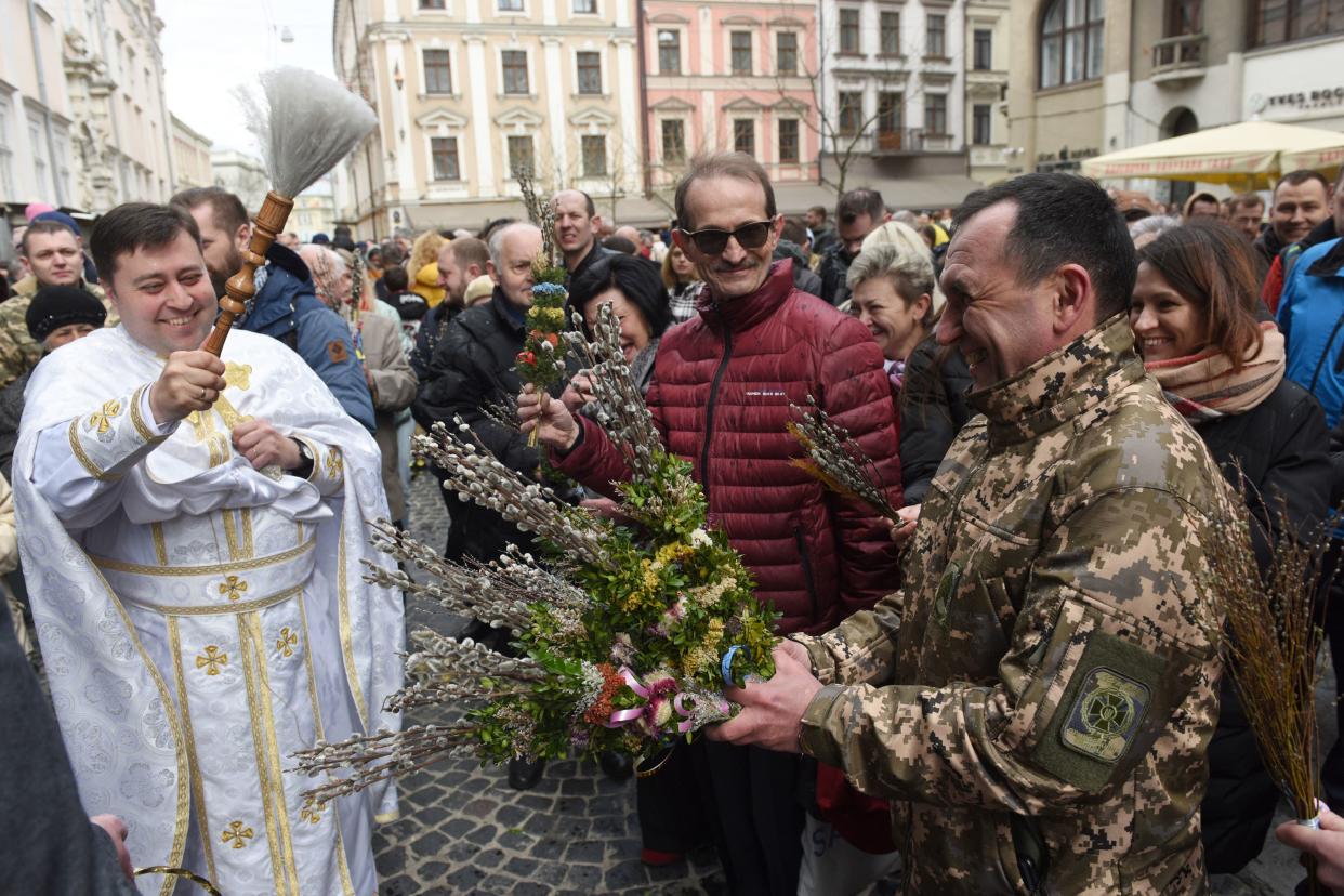 A priest blesses a member of the Ukrainian military.