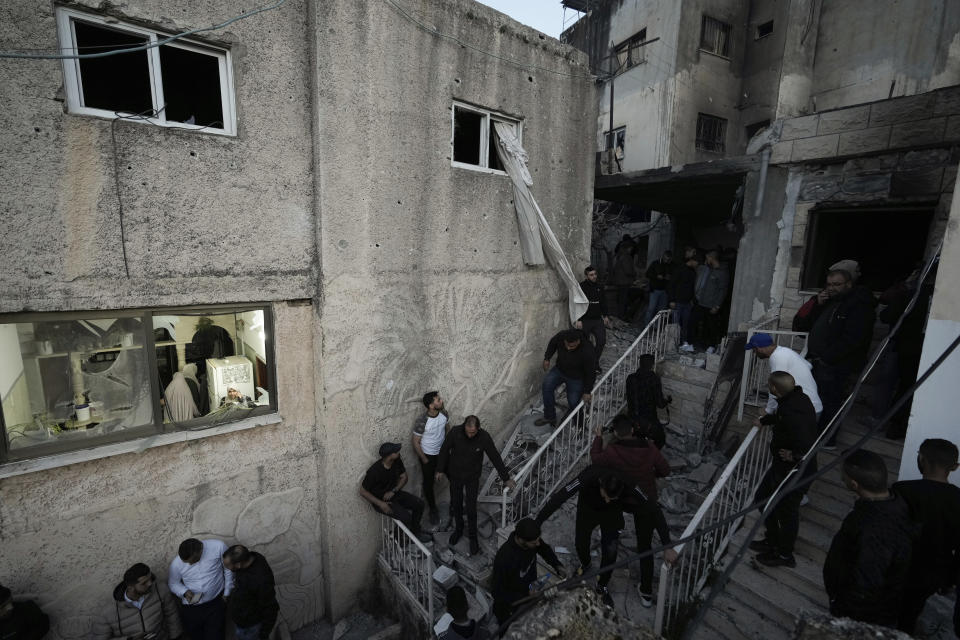 Palestinians inspect the site of a damaged building following an Israeli forces raid in the West Bank city of Jenin, Tuesday, March 7, 2023. The Israeli army has raided the occupied West Bank city of Jenin, leading to a gunbattle that killed at least six Palestinians, Israeli officials said the target of the raid was a militant who killed two Israeli brothers in a West Bank shooting last week. The man was among those killed on Tuesday. (AP Photo/Majdi Mohammed)