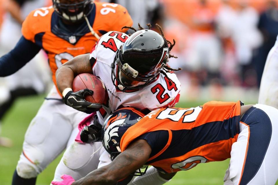Oct 9, 2016; Denver, CO, USA; Atlanta Falcons running back Devonta Freeman (24) is tackled by Denver Broncos linebacker Zaire Anderson (50) in the second half at Sports Authority Field at Mile High. The Falcons defeated the Broncos 23-16. Mandatory Credit: Ron Chenoy-USA TODAY Sports