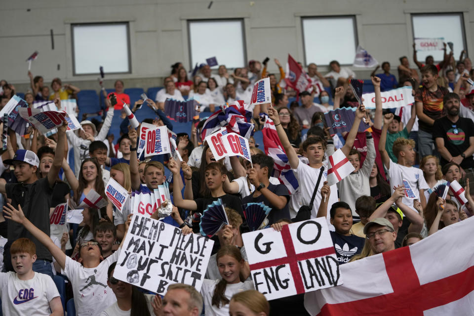 FILE - Young England fans on the stands wave flags before the start of the Women Euro 2022 group A soccer match between England and Norway at Brighton & Hove Community Stadium in Brighton, England, Monday, July 11, 2022. The march to Sunday's final against Germany has energized people throughout England, with the team's pinpoint passing and flashy goals attracting record crowds, burgeoning TV ratings and adoring coverage. The Lionesses, as the team is known, have been a welcome distraction from the political turmoil and cost-of-living crisis that dominate the headlines. (AP Photo/Alessandra Tarantino, File)