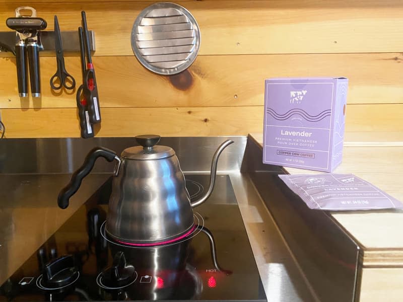 Electric stove top with metal kettle and purple coffee box