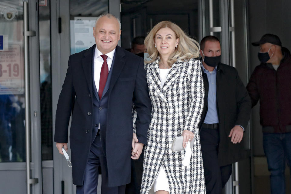 Incumbent Moldovan President Igor Dodon and his wife Galina smile while walking out of a voting station during the country's presidential election runoff in Chisinau, Moldova, Sunday, Nov. 15, 2020. Moldovans returned to the polls Sunday for the second round of voting in the country's presidential election, facing a choice between the staunchly pro-Russian incumbent and his popular pro-Western challenger after former prime minister, Maia Sandu, who beat the odds to win the first round on November 1 with over 36 percent of to vote, leaving the incumbent, President Igor Dodon, trailing her by over 3.5 points. (AP Photo/Roveliu Buga)