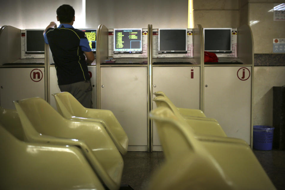 A Chinese investor uses a computer terminal as he monitors stock prices at a brokerage house in Beijing, Friday, Aug. 2, 2019. Asian stock markets plunged Friday after President Donald Trump's surprise threat of tariff hikes on additional Chinese imports. (AP Photo/Mark Schiefelbein)