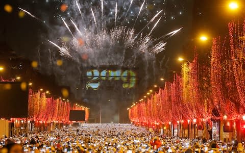 Fireworks illuminate the sky over the Arc de Triomphe during the New Year's Day celebrations on the Champs Elysees, in Paris - Credit: AP