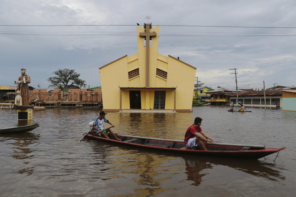 Residents navigate flooded streets in Anama, Amazonas state, Brazil, Thursday, May 13, 2021. (AP Photo/Edmar Barros)