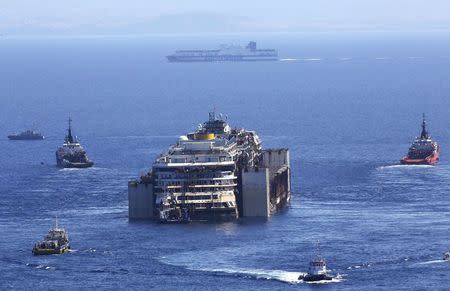 A Grimaldi lines ship sails in front of the cruise liner Costa Concordia during the refloat operation maneuvers at Giglio Island July 23, 2014. REUTERS/ Alessandro Bianchi