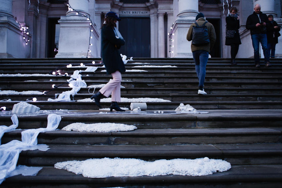 People walk across the light-and-sound installation 'The Depth Of Darkness The Return Of The Light', by artist Anne Hardy, on the steps of the Tate Britain art gallery in London, England, on November 30, 2019. Hardy's piece, unveiled today as the gallery's 2019 Winter Commission, is intended to make the building resemble a 'marooned temple'. A thundery soundtrack accompanies the physical objects fixed to the steps and masonry of the front of the gallery. The installation will remain in place until January 26 next year. (Photo by ) | David Cliff—NurPhoto/Getty Images