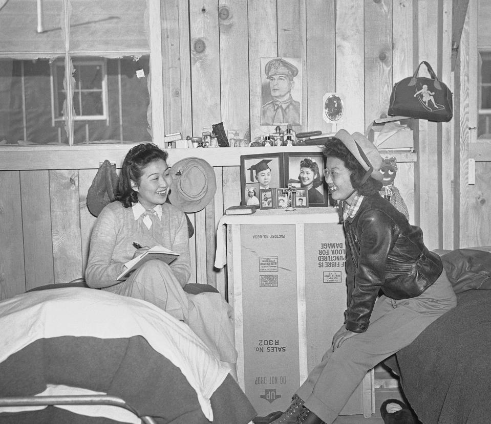 <p>A picture of Gen. Douglas MacArthur, military nemesis of the Japanese forces, hung in a flace of honor, March 24, 1942 on the wall of the room of Gene Hashimoto (left) and Mary Wada was at the reception center established at Manzanar in the Owens Valley for Japanese evacuated from Los Angeles. Miss Hashimoto wrote friends at home of the new life at the hastily constructed community. (AP Photo) </p>