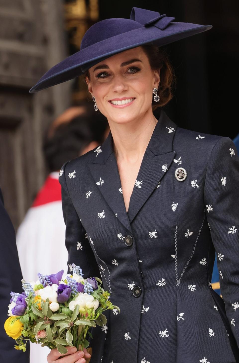Catherine, Princess of Wales with a bouquet of flowers smiles as she departs the 2023 Commonwealth Day Service at Westminster Abbey