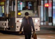 A man wearing a face mask walks in downtown Frankfurt, Germany, early Monday, Oct. 19, 2020. (AP Photo/Michael Probst)